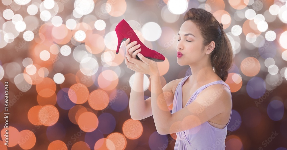 Young woman kissing new footwear over bokeh