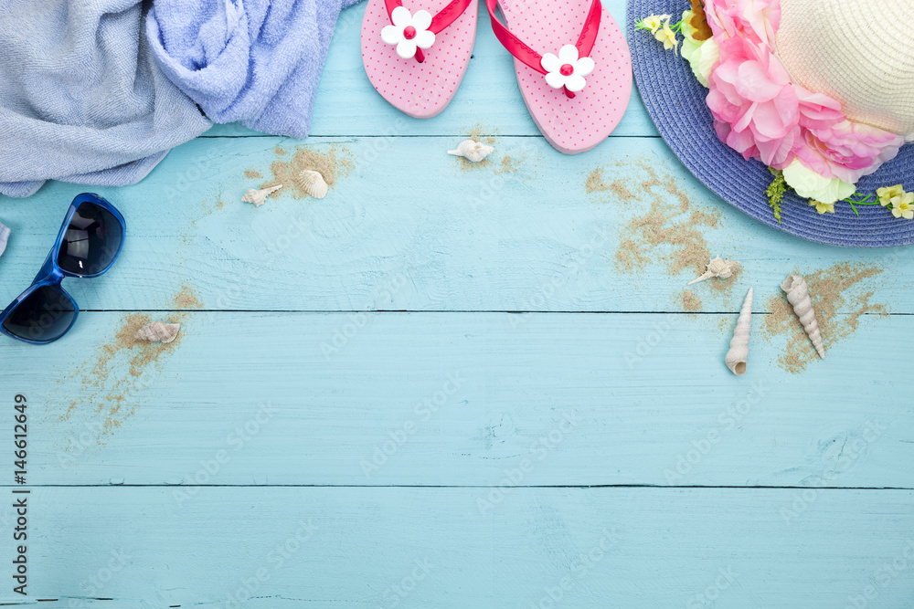 Sun glasses with beach shoes and beautiful hat beach,towel on wooden background.