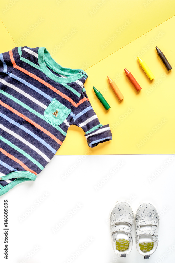 children flat lay with clothes yellow background top view space for text