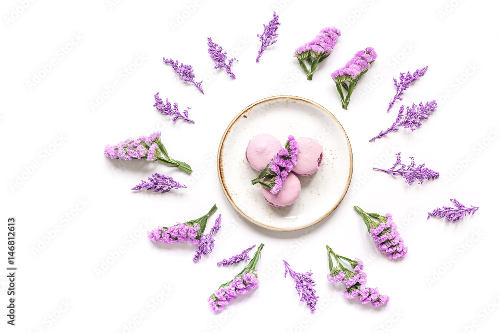 macaroons and flowers for light breakfast on white desk background top view