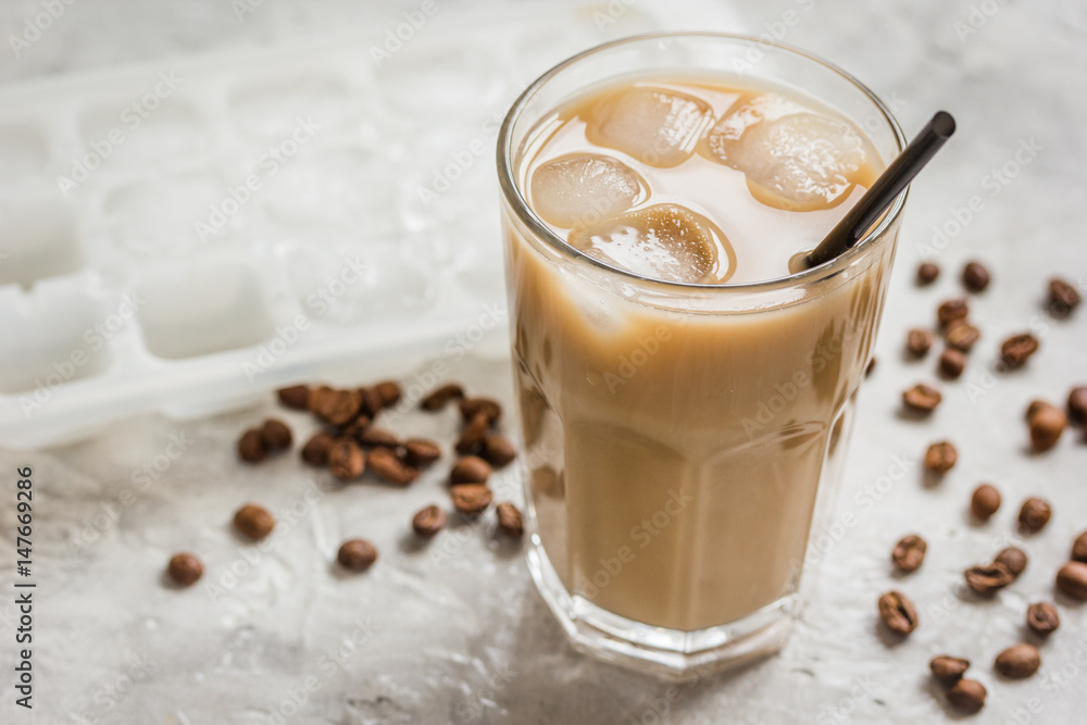 coffee ice cubes and beans with latte on stone desk background