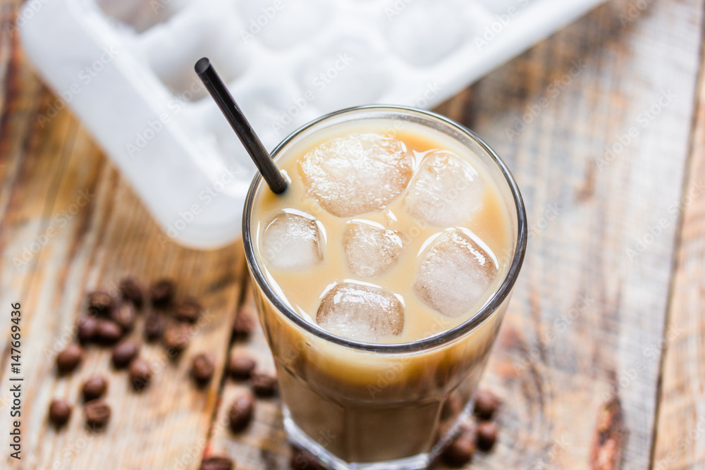 iced coffee with beans for cold summer drink on wooden background