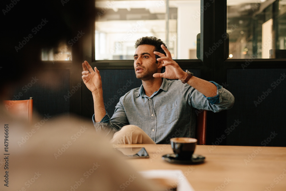 Man explaining business strategy to colleagues in conference roo