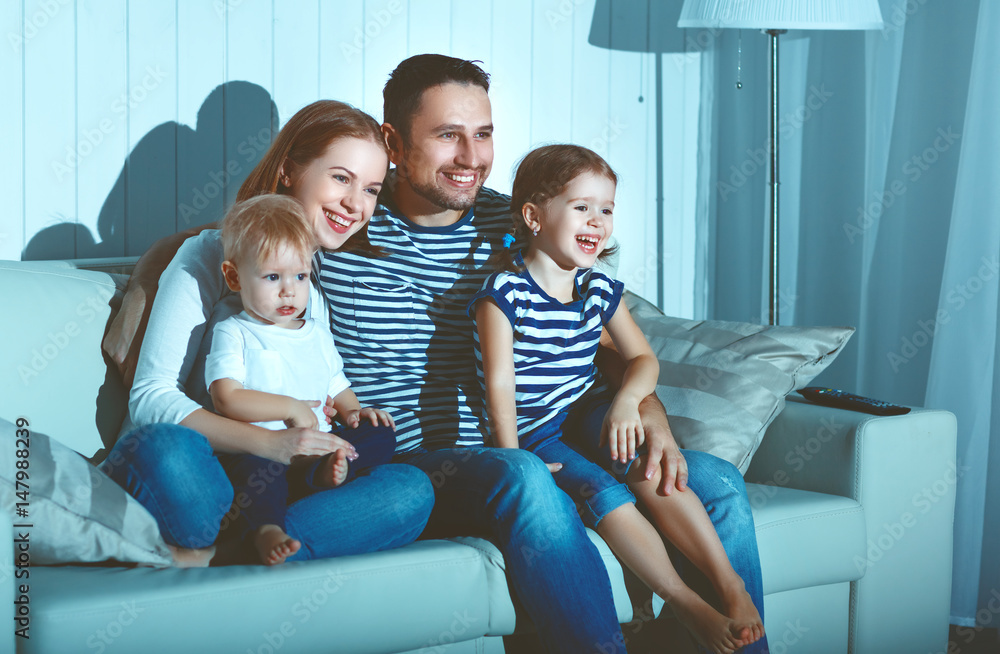 Family watching television at home on sofa