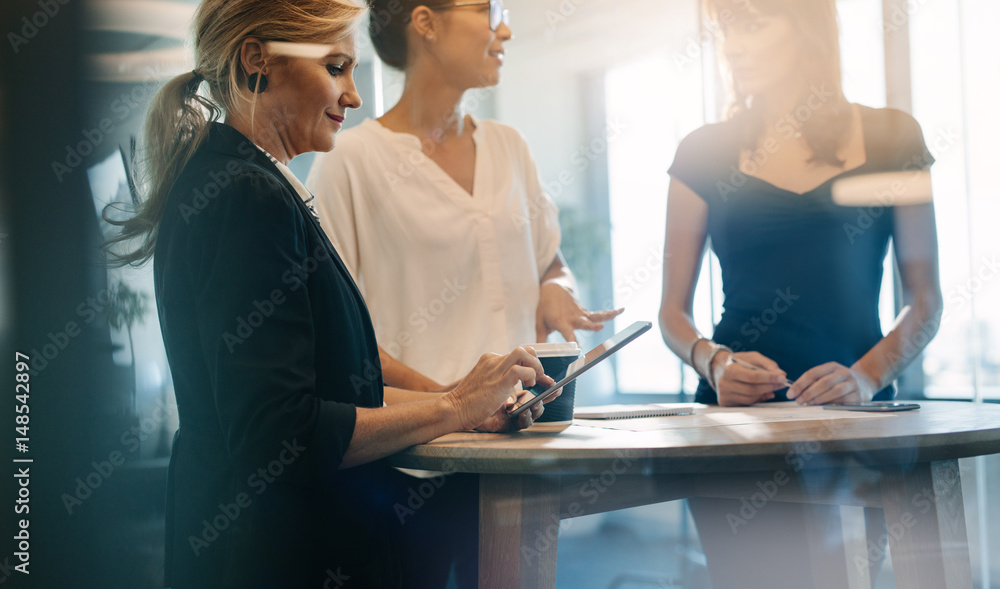 Three female colleagues having a standing meeting