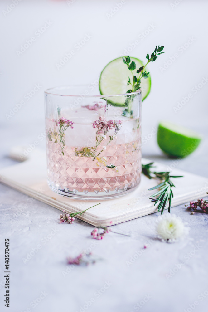 natural cocktail with herbs and cut lime on stone desk background