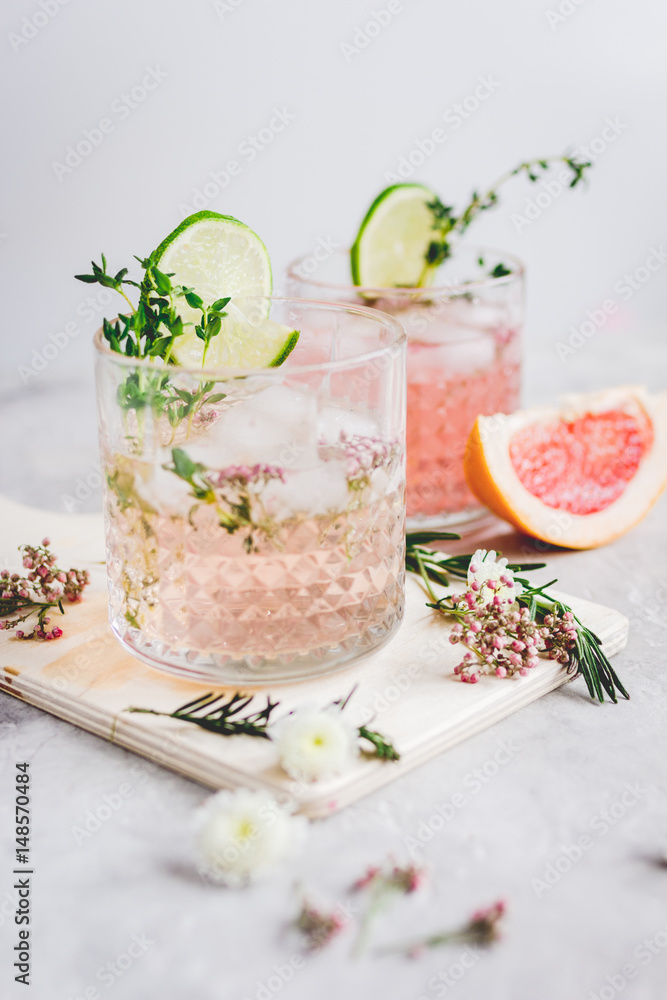 pink fresh cocktail with grape-fruit and cut lime on stone desk background