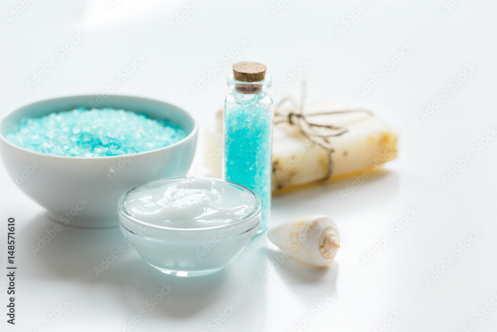 blue set for bath with salt and shells on white table background