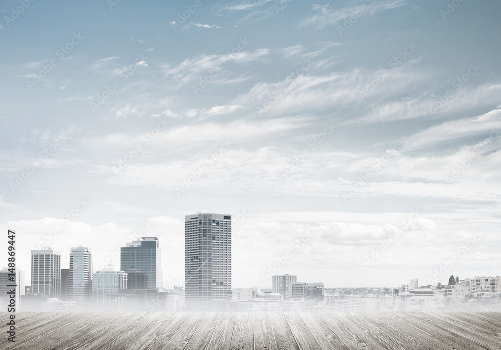 Modern urban buildings skyscrapers blue cloudy sky background and wooden textured platform