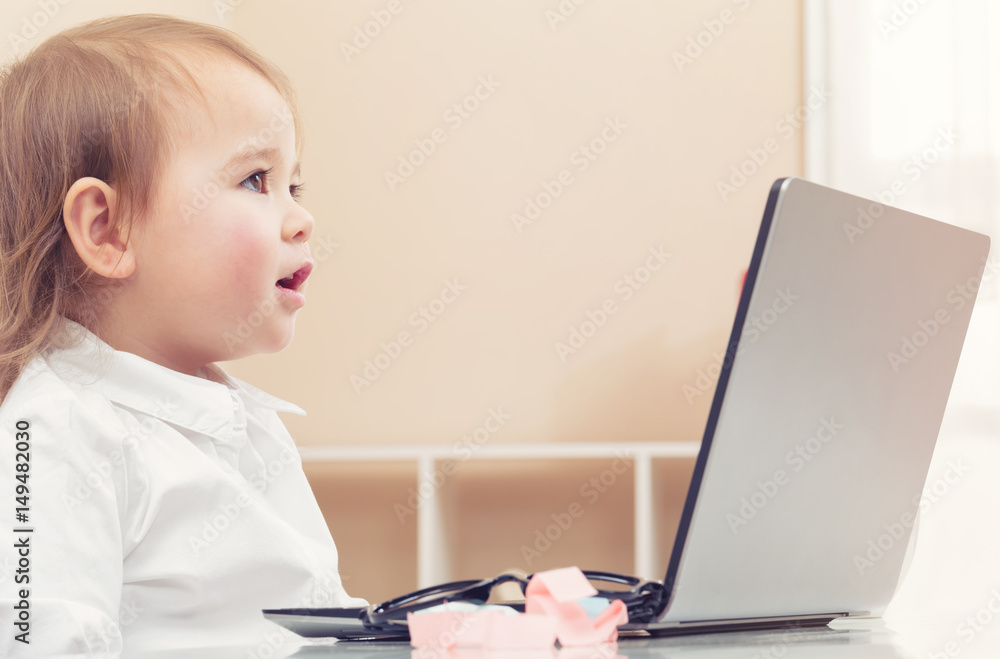 Happy toddler girl on her laptop