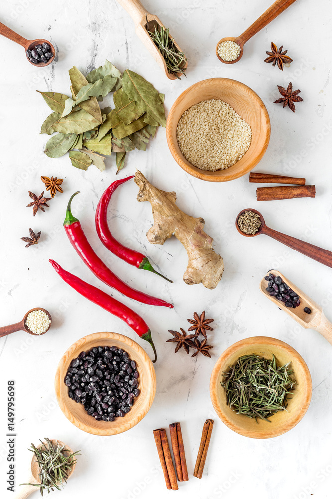 Spices, chili and herbs on white kitchen table background top view