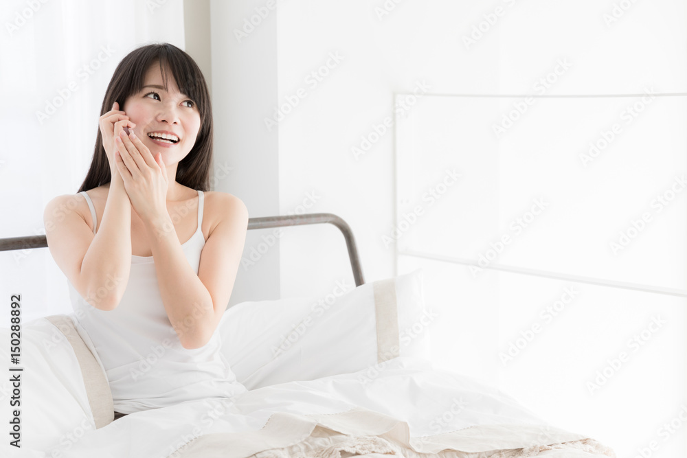 attractive asian woman relaxing in bedroom