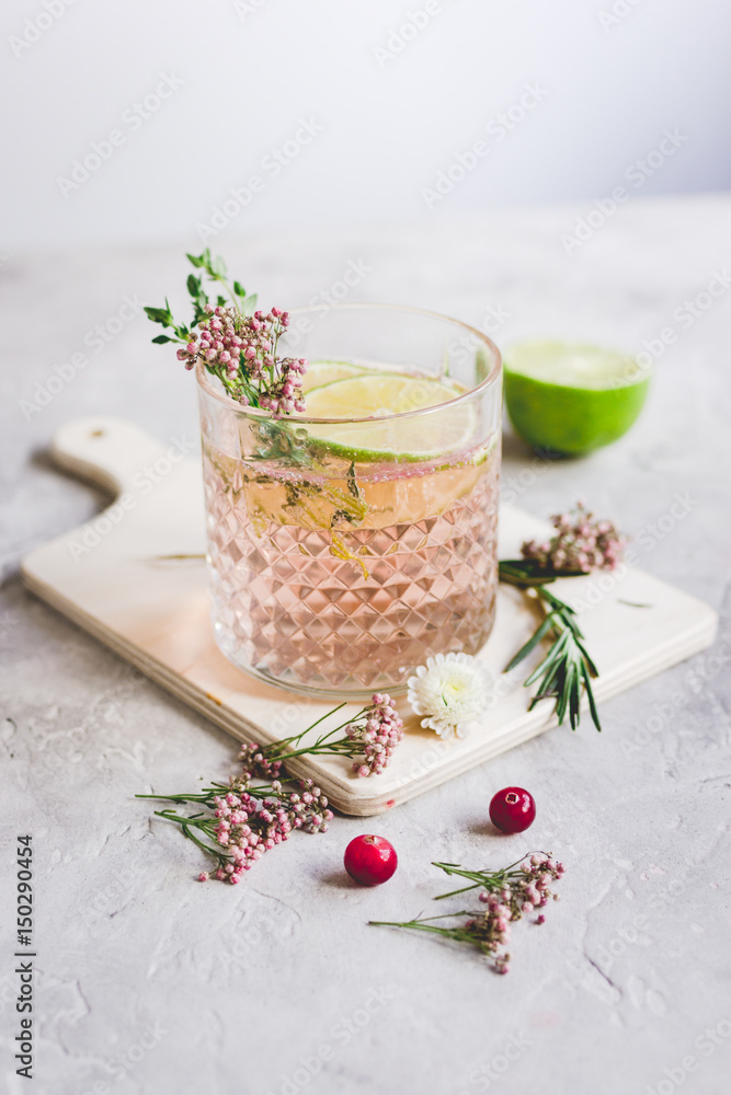 making cocktails in glasses with lime and berries on stone kitchen desk background