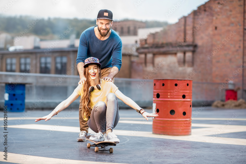 Friends having fun with skateboard outdoors