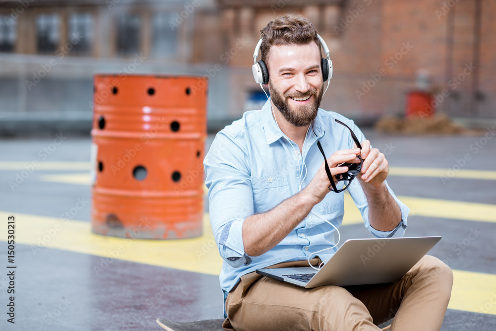 Hipster working with laptop on the rooftop