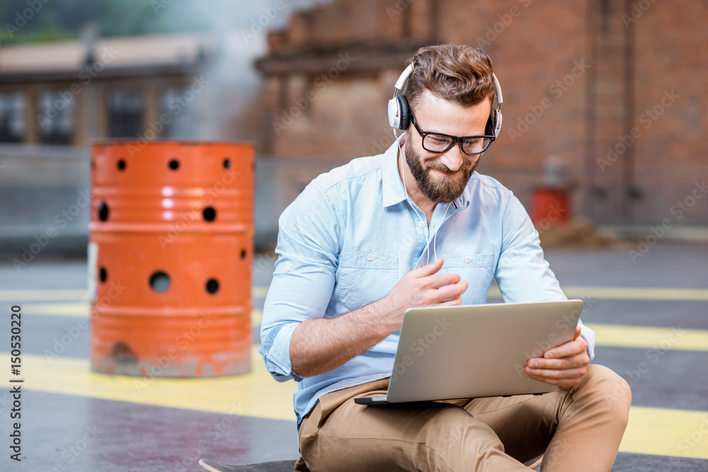 Hipster working with laptop on the rooftop