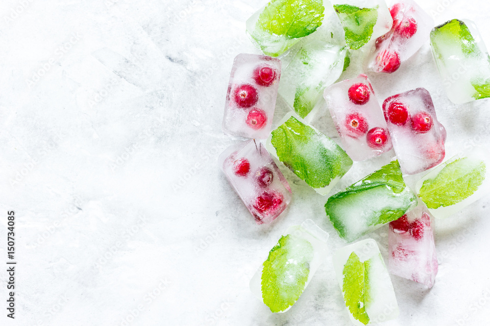 mint and red berries in ice cubes stone background top view mockup