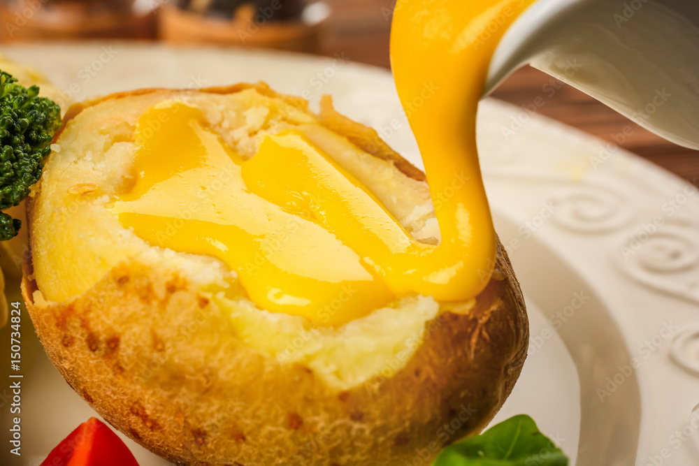 Baked potato with cheese sauce, closeup