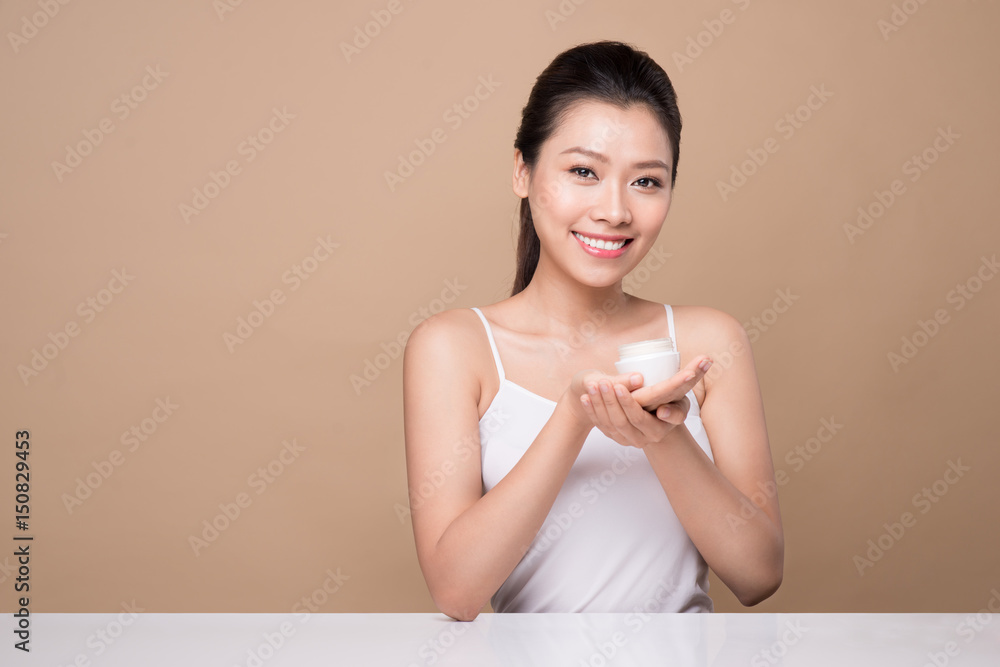 Skincare. Beautiful asian woman show moisturizer or lotion product.