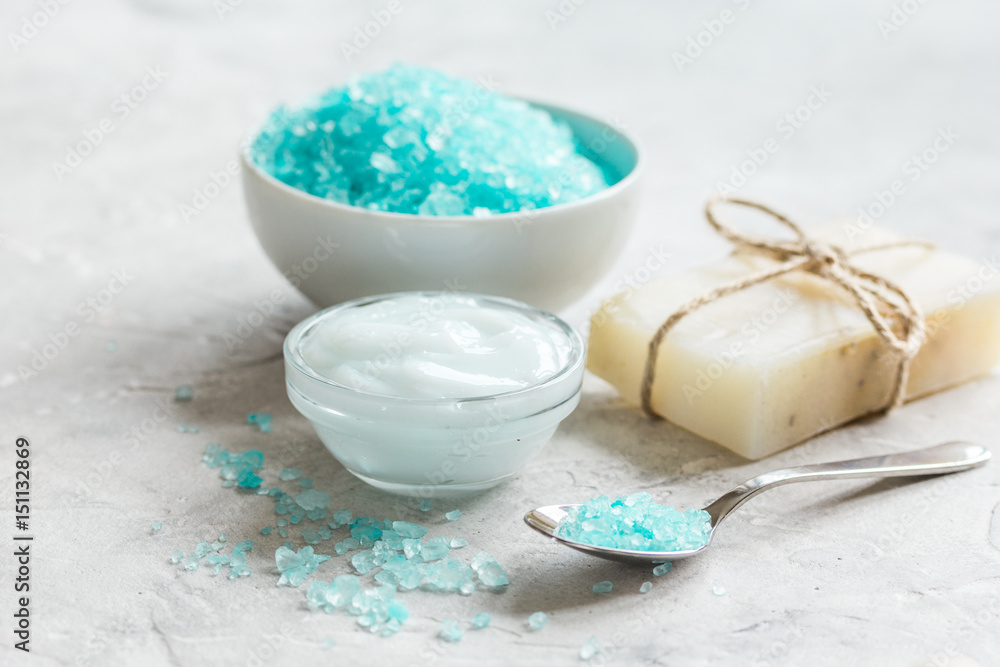 spa composition with blue sea salt and natural soap on stone desk background