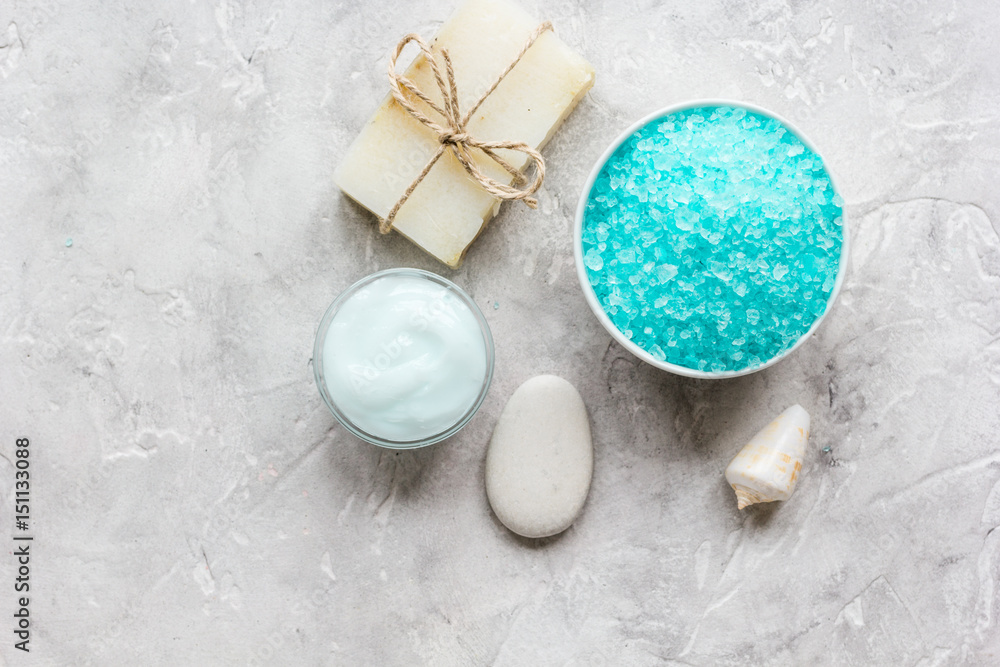 Home cosmetic with cream and blue sea salt on stone background top view mock-up