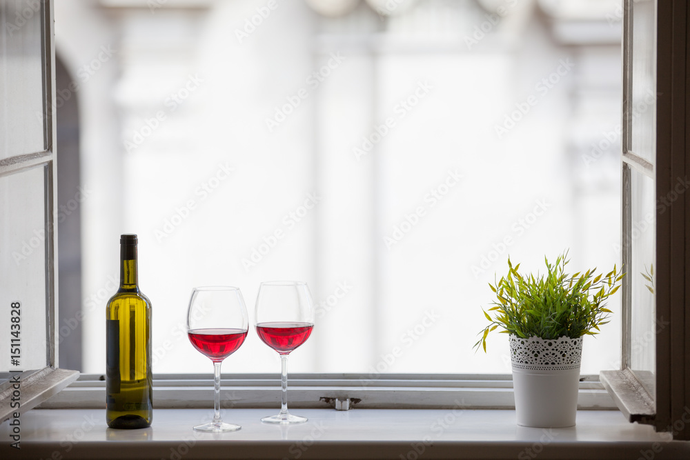 Relax and enjoy a glass of wine, day off and holiday concept. Pair of wine glasses on a hotel window