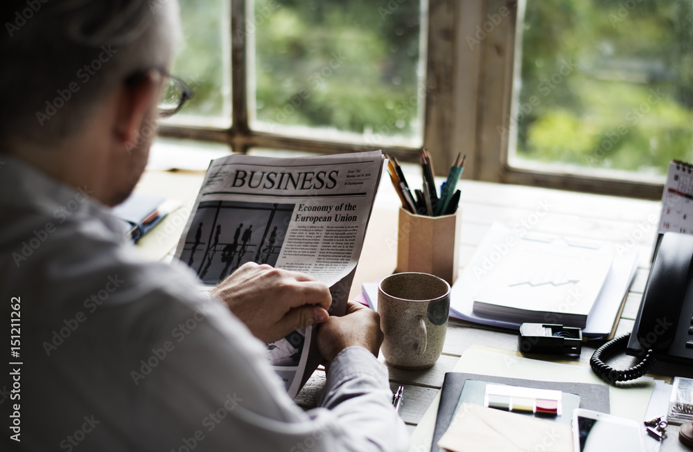 Businesspeople Reading Newspaper at Office Updating News