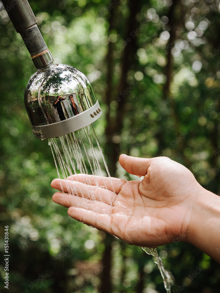 hand and droplets of water from shower