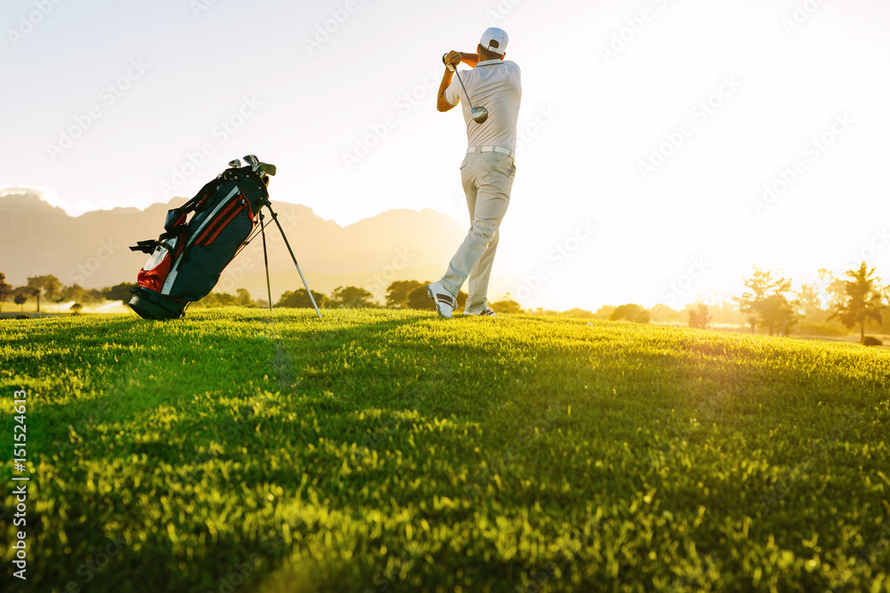 Professional golfer taking shot on golf course