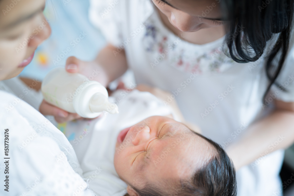 妈妈和妈妈给亚洲新生儿喂奶