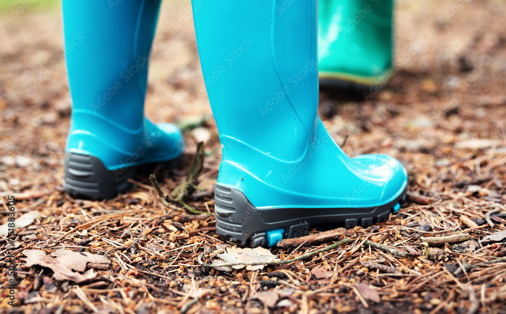 Children standing in wellies in the forest in summer