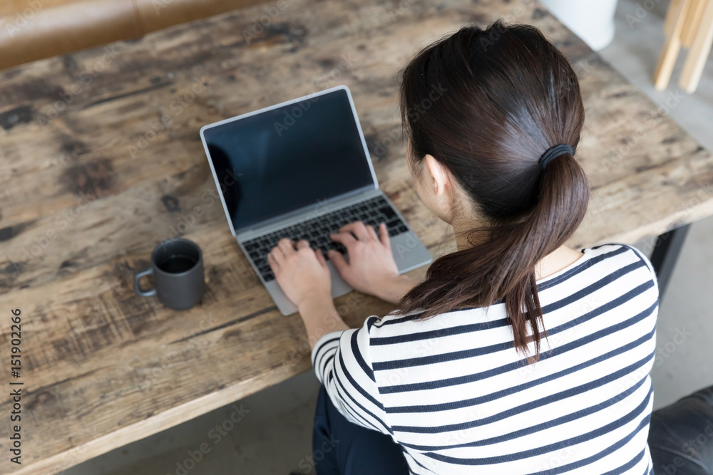 young asian woman using laptop in cafe