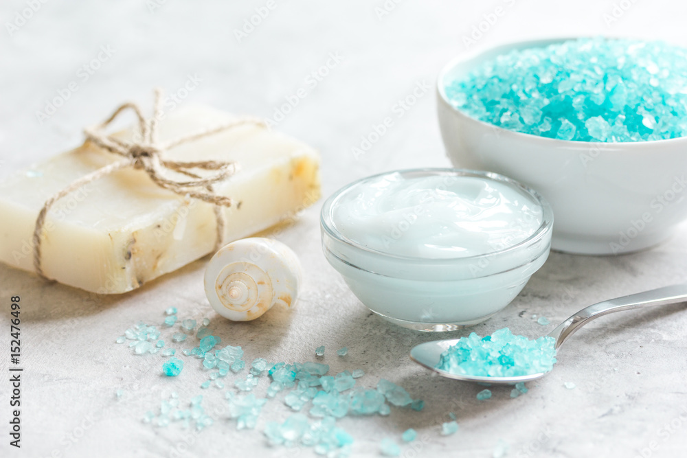 blue set for bath with salt and shells on stone table background