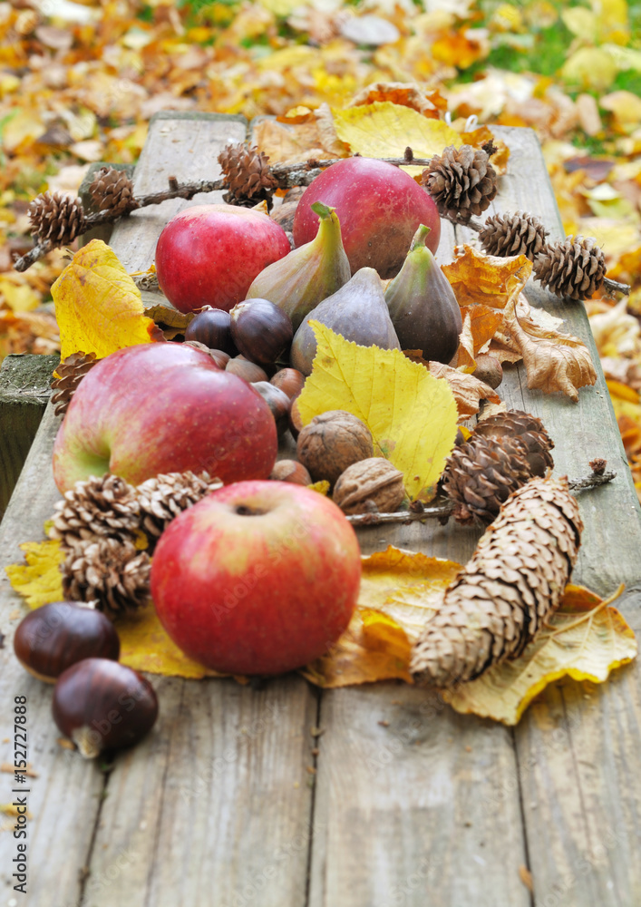 pommes et autres fruit dautomne dans feuilles jaunes sur  planche