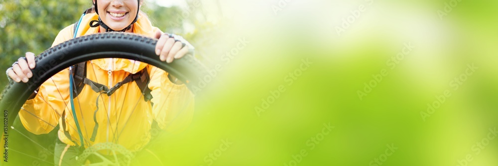 Portrait of female biker repairing mountain bike