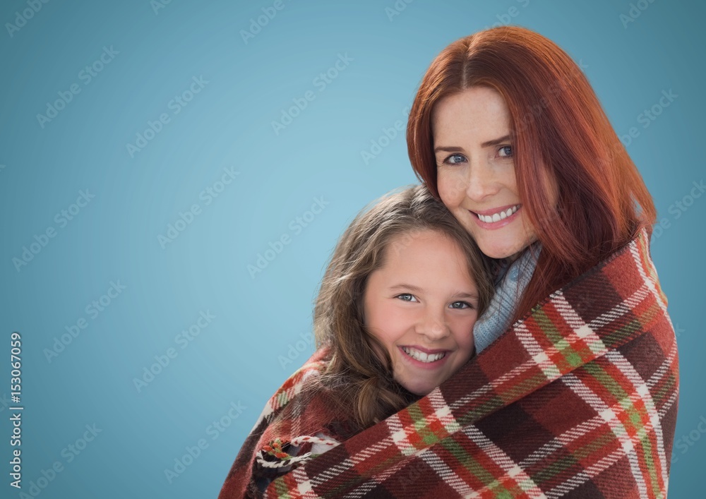 Mother hugging daughter against blue background