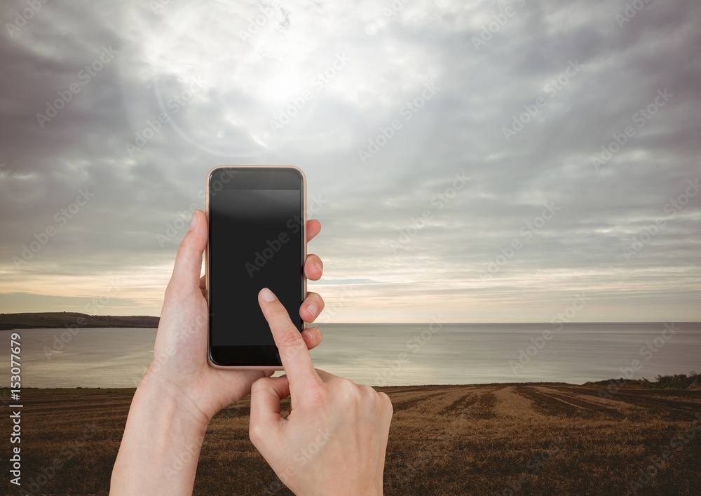 Hand Touching Mobile phone with evening sky 