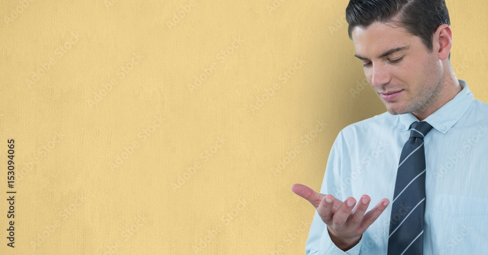 Man looking at hand against yellow background