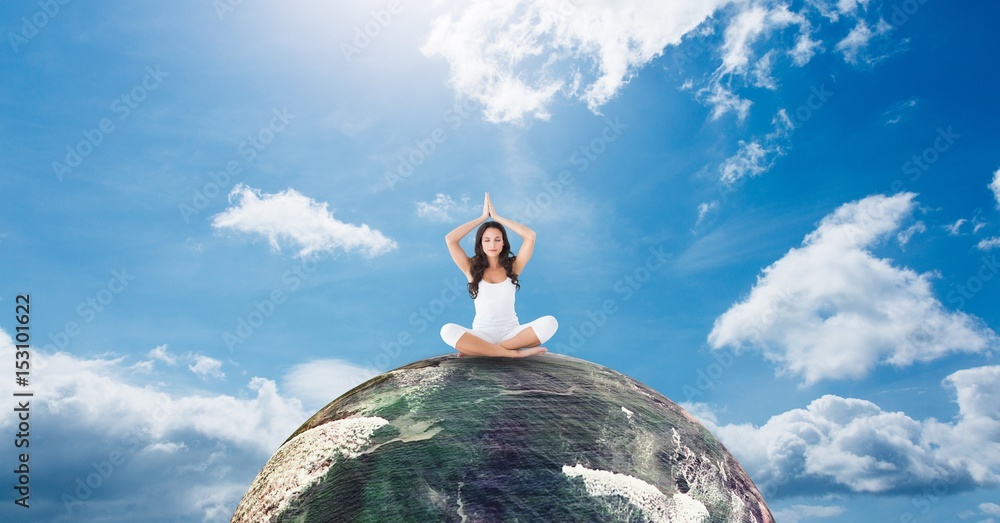 Woman meditating on earth against sky