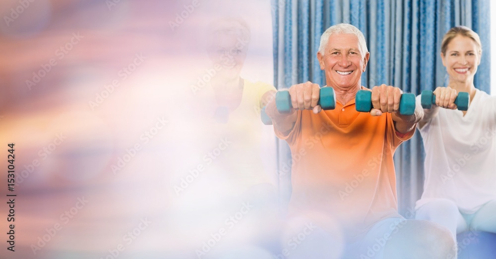 Senior man with woman lifting dumbbells in gym