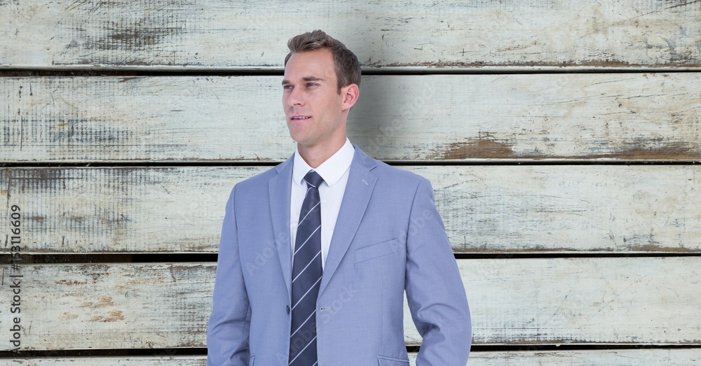 Thoughtful businessman standing against wall