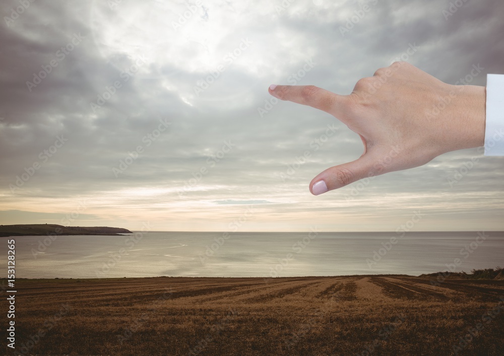 Hand Touching evening sky over landscape