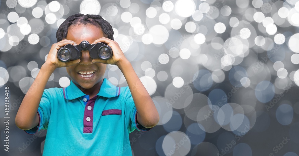 Girl holding binoculars over defocused background