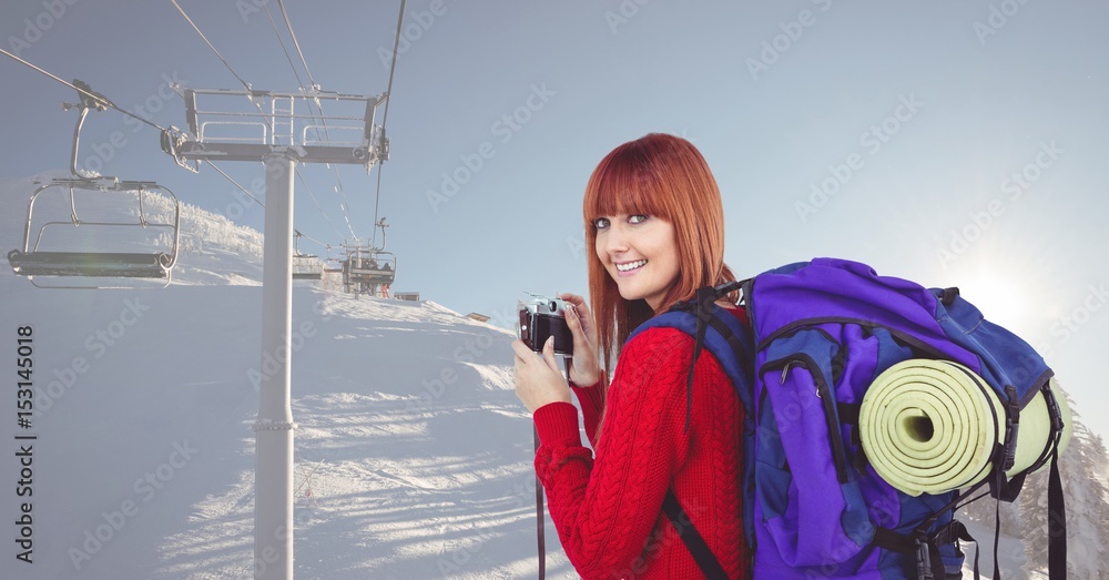 雪地上手持相机的女徒步旅行者的肖像