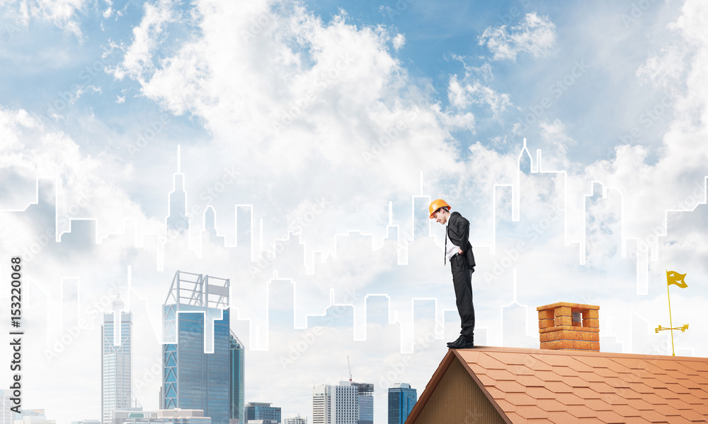 Engineer man standing on roof and looking down. Mixed media