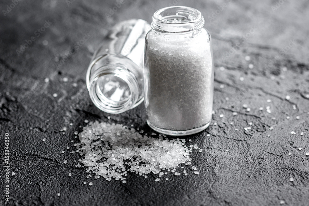 Cooking set with salt in glass bottle on dark background