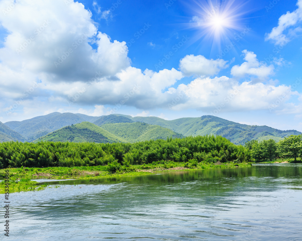 River and green mountains under the blue sky