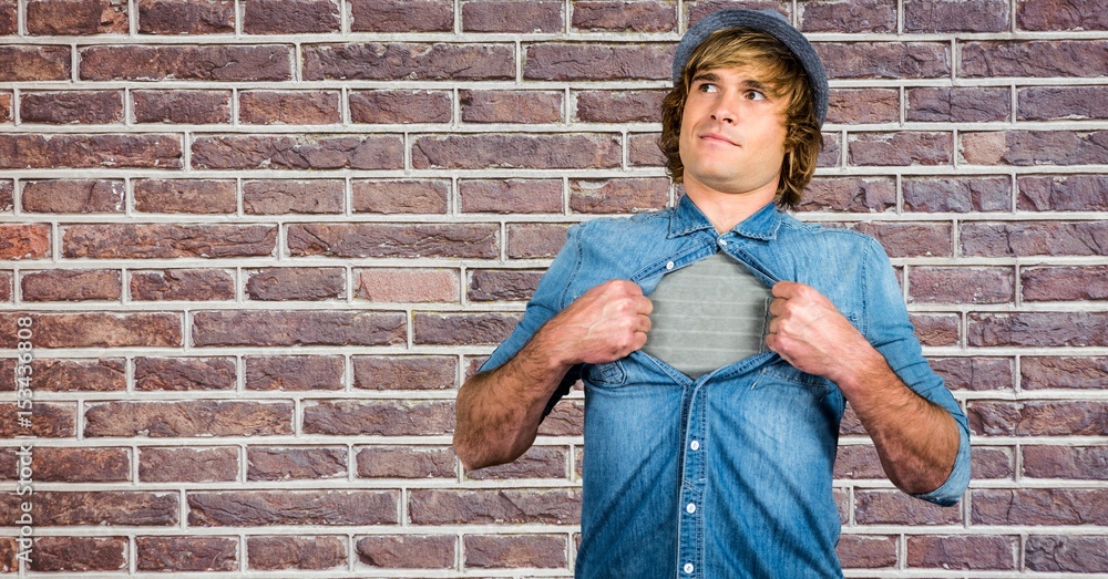 Hipster tearing shirt against brick wall