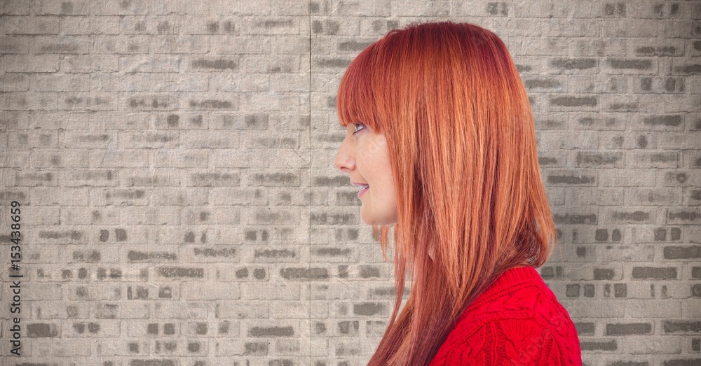 Redhead woman looking away against wall