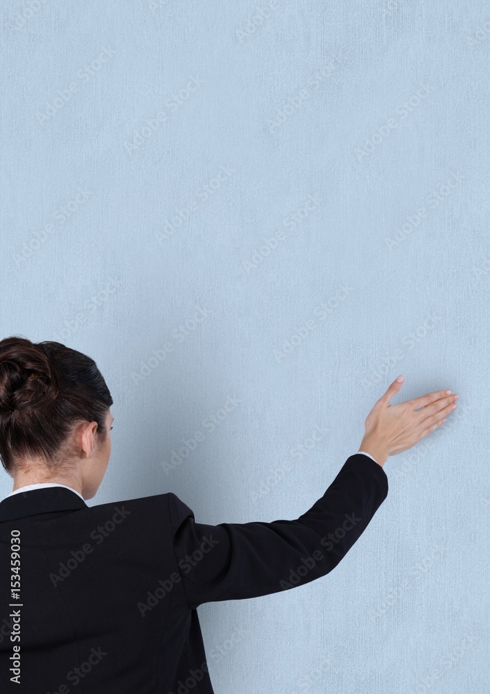 Rear view of businesswoman touching blue background